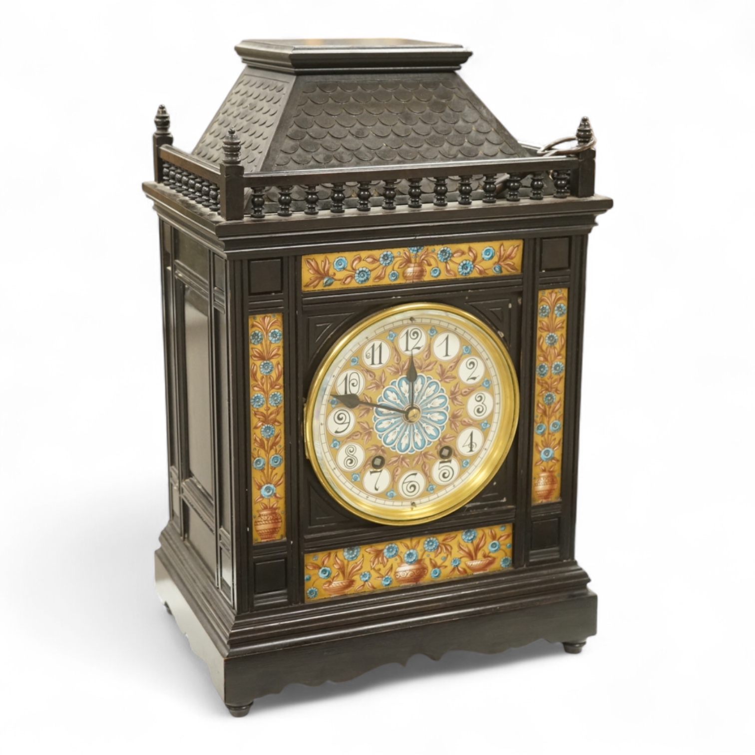 A Victorian Aesthetic Movement ebonised architectural mantel clock, probably designed by Lewis Foreman Day, the eight day chiming movement marked G.V. no. 39837, with Elourdelet lever, with figure and foliage decorated g